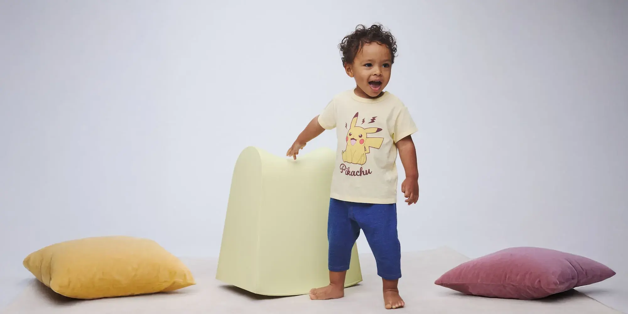 bayi sedang bermain memakai baju kuning