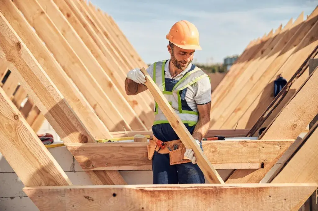 focused-builder-is-adjusting-a-wooden-bar-to-a-roof-carcass-1024x682-1-1